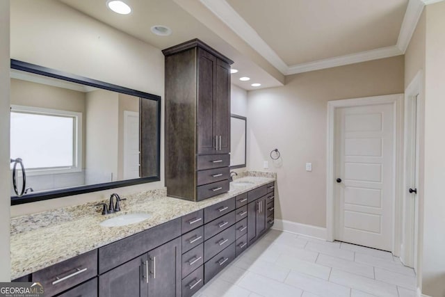 full bath featuring crown molding, a sink, baseboards, and double vanity