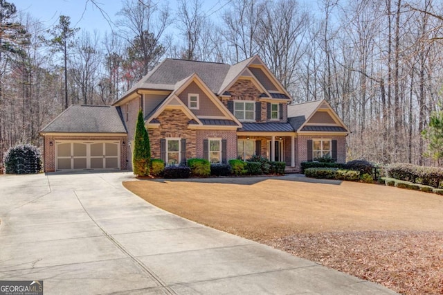 craftsman-style home with a garage, concrete driveway, metal roof, a standing seam roof, and a front yard