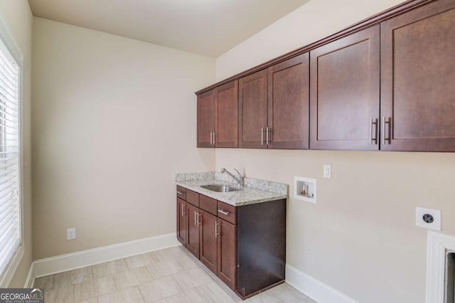 clothes washing area featuring cabinet space, baseboards, hookup for a washing machine, hookup for an electric dryer, and a sink