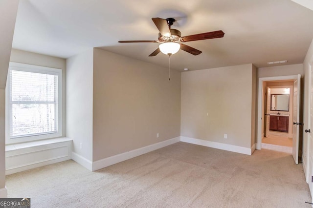 unfurnished room featuring baseboards, a ceiling fan, visible vents, and light colored carpet