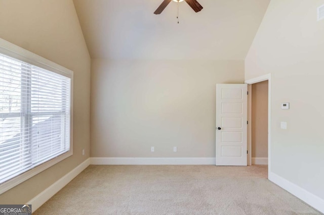 unfurnished room featuring lofted ceiling, light carpet, ceiling fan, and baseboards