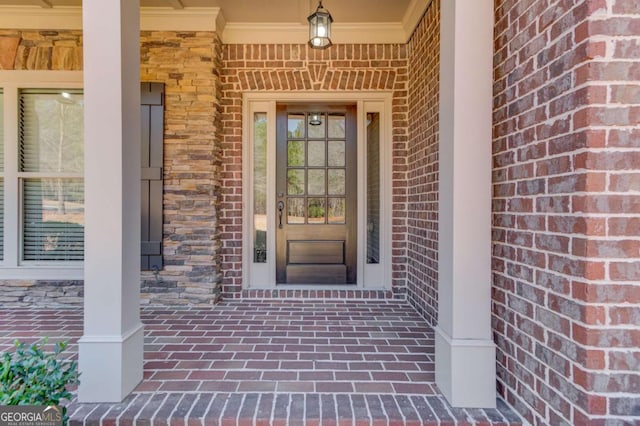 doorway to property featuring covered porch and brick siding