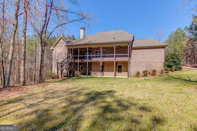 rear view of property with a deck, brick siding, a lawn, and a chimney