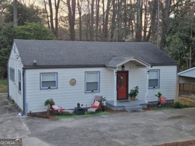 view of front of home featuring driveway and roof with shingles