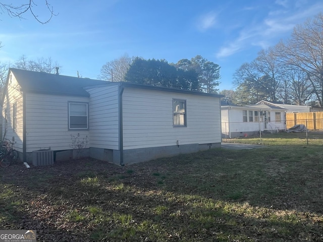 rear view of house featuring crawl space, a yard, central AC, and fence