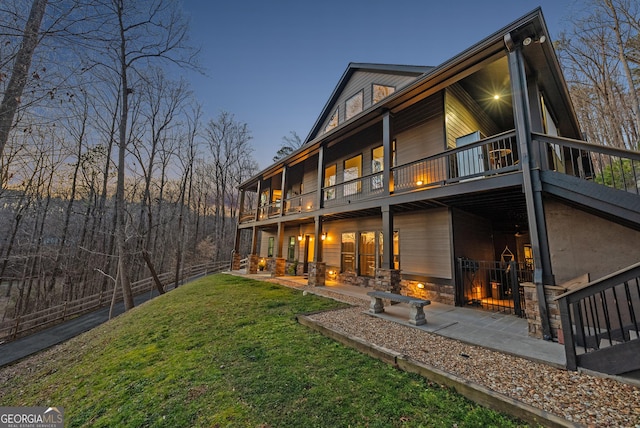 rear view of house featuring a yard, a patio area, and a balcony