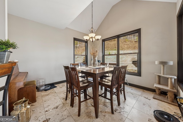 dining area featuring baseboards, high vaulted ceiling, and an inviting chandelier