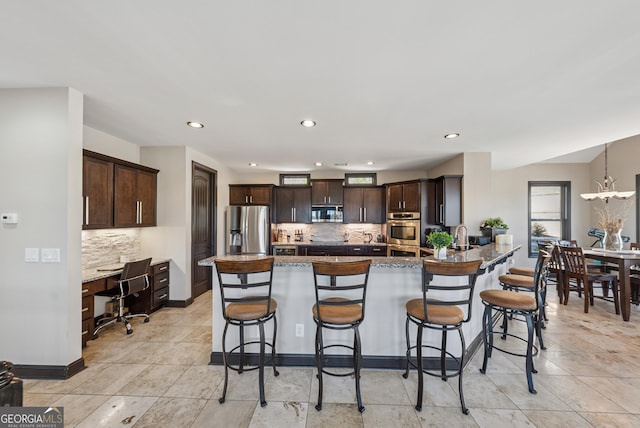 kitchen with stainless steel appliances, dark brown cabinetry, a peninsula, and a kitchen breakfast bar