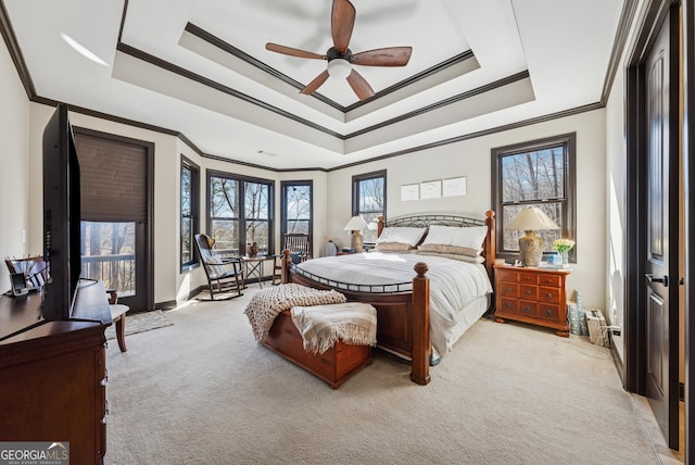 carpeted bedroom with baseboards, ceiling fan, a raised ceiling, and crown molding