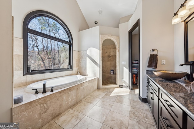 full bathroom with a garden tub, vanity, vaulted ceiling, a tile shower, and tile patterned floors