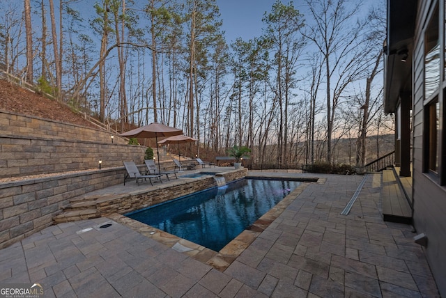 view of pool with a patio area, a fenced backyard, and a pool with connected hot tub