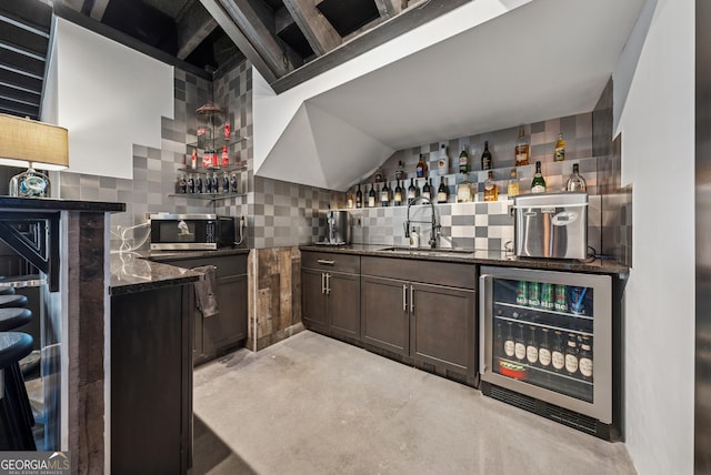 bar featuring wine cooler, stainless steel microwave, decorative backsplash, a sink, and wet bar