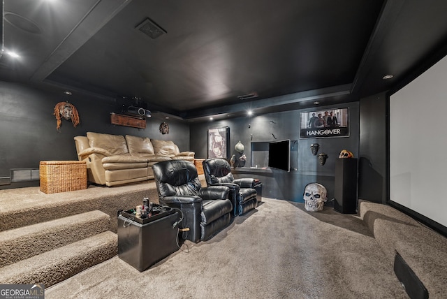 cinema featuring visible vents, a raised ceiling, and carpet flooring