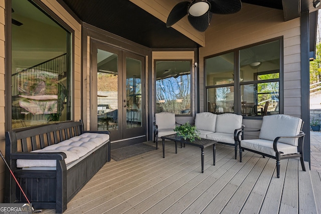 wooden deck with french doors, ceiling fan, and an outdoor living space