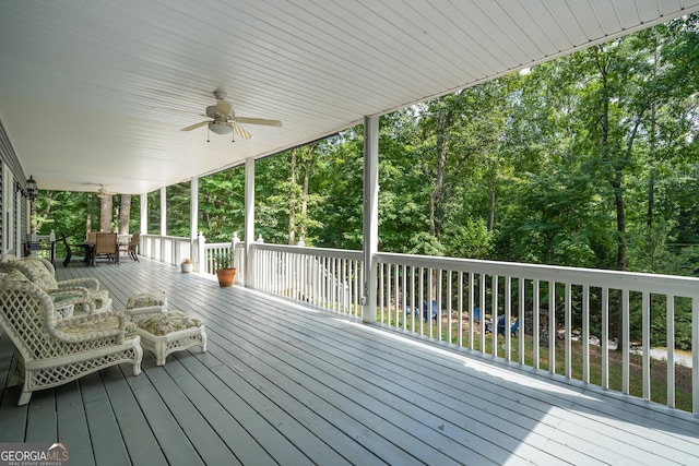 deck with outdoor dining space and a ceiling fan