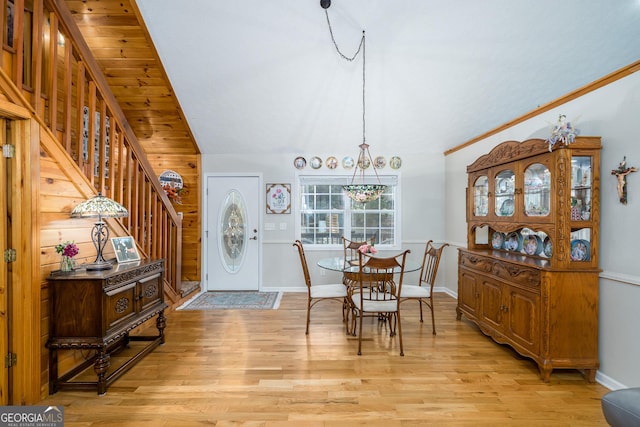 dining space with stairway, lofted ceiling, baseboards, and light wood-style flooring