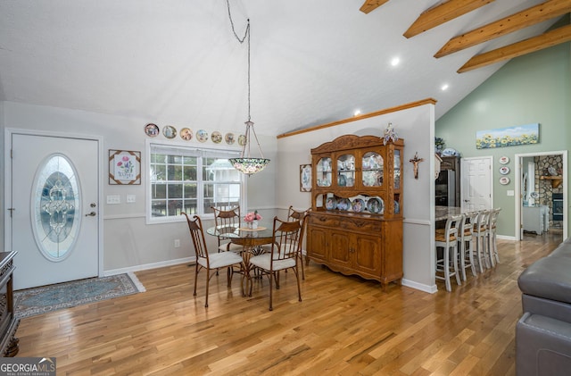 dining space with beamed ceiling, baseboards, high vaulted ceiling, and light wood finished floors