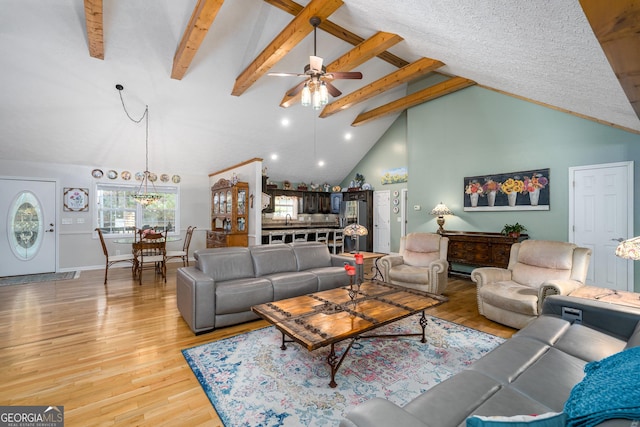 living room with beam ceiling, light wood-style flooring, high vaulted ceiling, and a ceiling fan