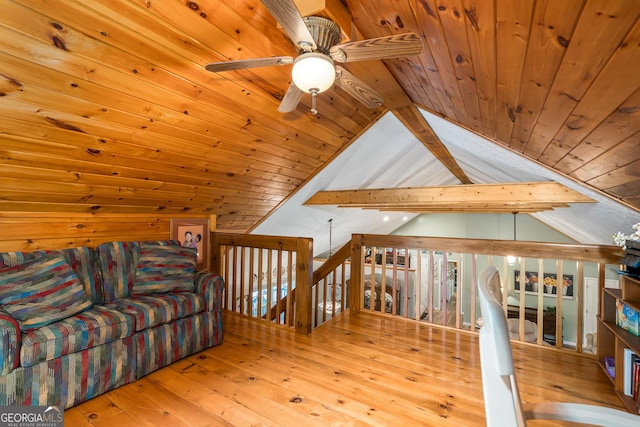 unfurnished room with an upstairs landing, wooden ceiling, lofted ceiling with beams, and hardwood / wood-style floors