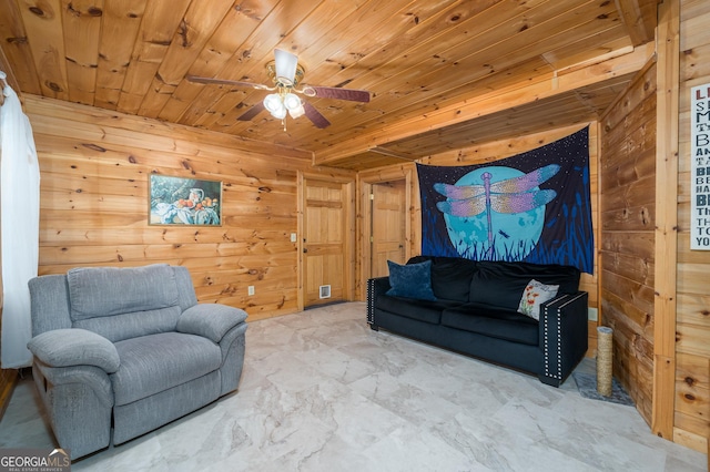 living room with wooden walls, marble finish floor, wood ceiling, and a ceiling fan