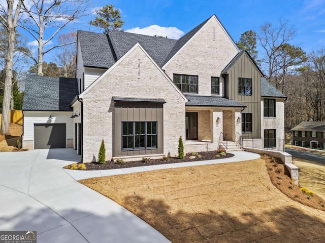 view of front of house featuring a garage, concrete driveway, brick siding, and board and batten siding