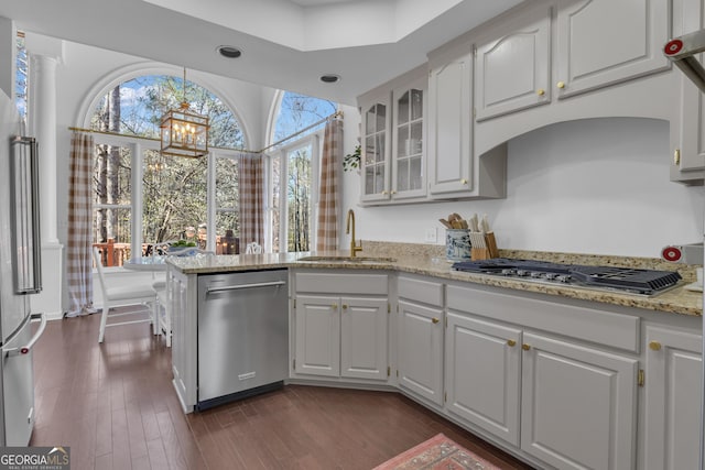 kitchen with a sink, glass insert cabinets, stainless steel appliances, white cabinetry, and dark wood-style flooring