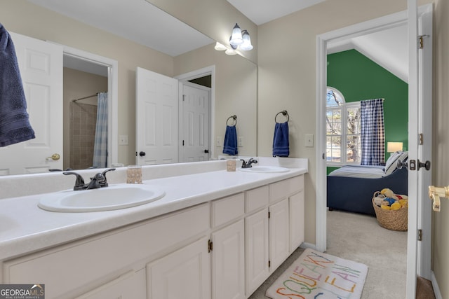 bathroom featuring a sink, connected bathroom, double vanity, and vaulted ceiling