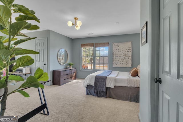 bedroom featuring visible vents, an inviting chandelier, and carpet flooring