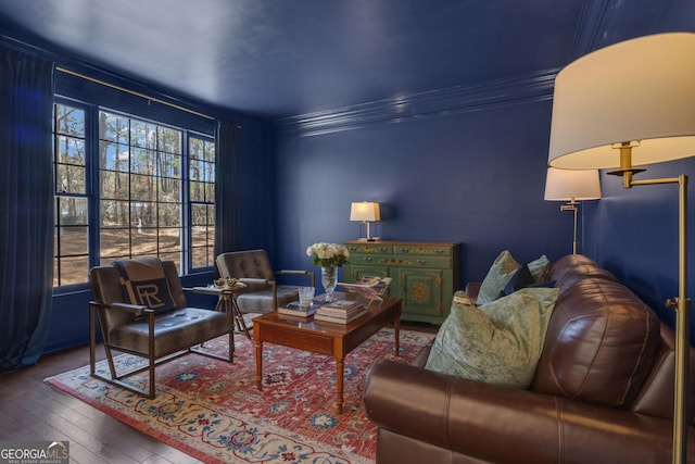 living area with crown molding and hardwood / wood-style flooring