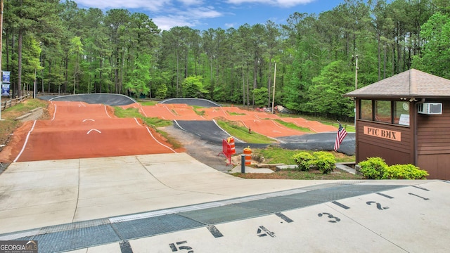 view of community featuring a wooded view and driveway