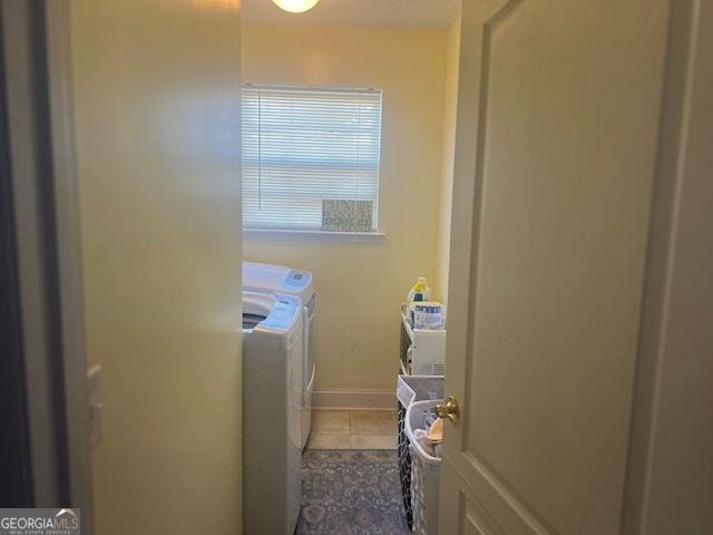 washroom featuring laundry area, washer and clothes dryer, baseboards, and tile patterned floors