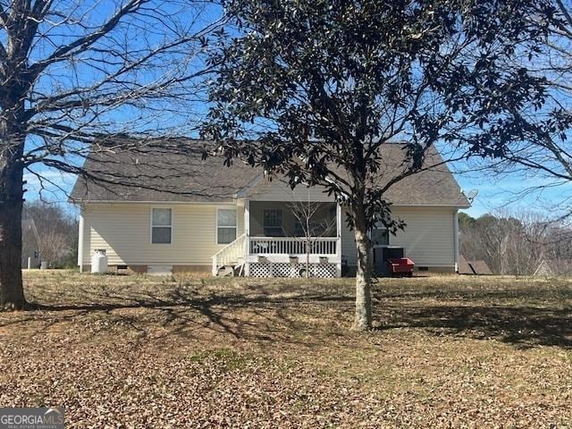 back of house with crawl space and a porch