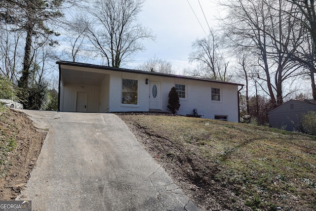 view of front of house featuring an attached carport, concrete driveway, and brick siding