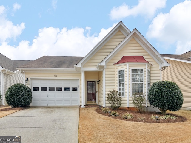 single story home with concrete driveway, roof with shingles, and an attached garage