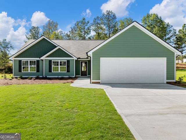 view of front of house featuring an attached garage, driveway, and a front yard