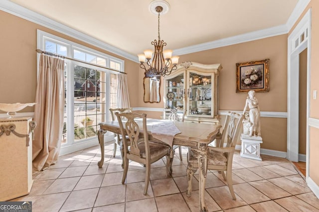 dining area featuring light tile patterned flooring, a notable chandelier, crown molding, and baseboards