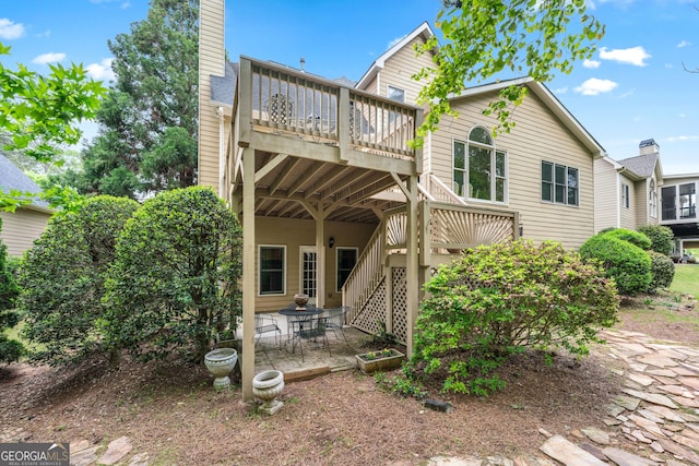 994 Fairview Club Cir, Dacula, GA 30019 - back of house featuring a wooden deck, a chimney, stairs, and a patio