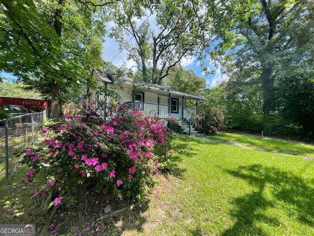 view of yard featuring a porch and fence