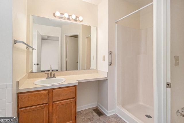 full bath with vanity, a shower stall, baseboards, and visible vents