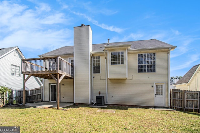 rear view of house featuring a yard, a fenced backyard, a chimney, and a patio