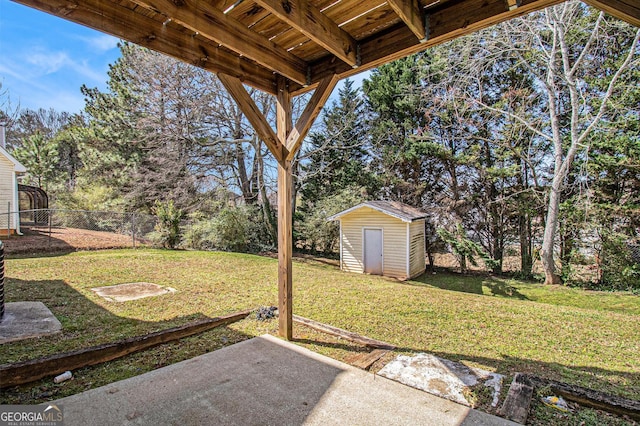 view of yard featuring a patio area, a shed, an outdoor structure, and fence