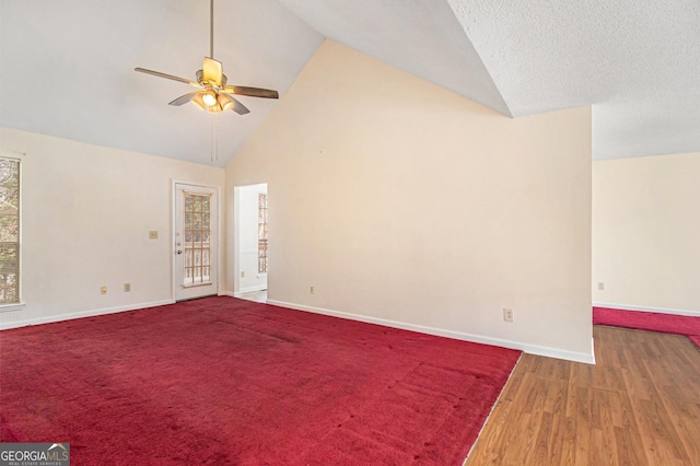 unfurnished room featuring wood finished floors, baseboards, high vaulted ceiling, and ceiling fan