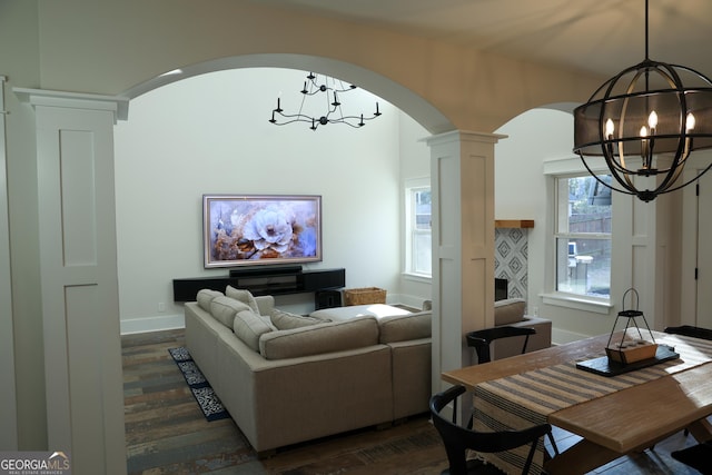793 Round Tree Ct, Lawrenceville, GA 30045 - living room with baseboards, a chandelier, decorative columns, arched walkways, and dark wood-style flooring