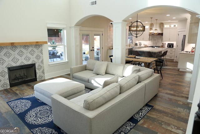 793 Round Tree Ct, Lawrenceville, GA 30045 - living area with a tiled fireplace, visible vents, dark wood-type flooring, and ornate columns