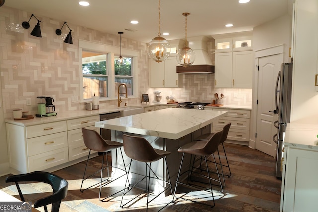 793 Round Tree Ct, Lawrenceville, GA 30045 - kitchen with a sink, a kitchen breakfast bar, a kitchen island, freestanding refrigerator, and custom exhaust hood
