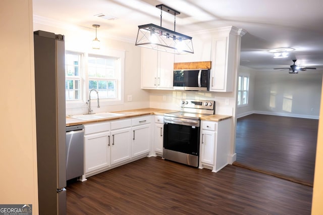 kitchen with stainless steel appliances, a healthy amount of sunlight, a sink, and white cabinetry