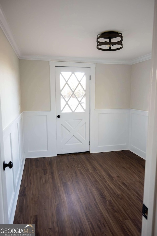 entryway with ornamental molding, dark wood-style flooring, and wainscoting