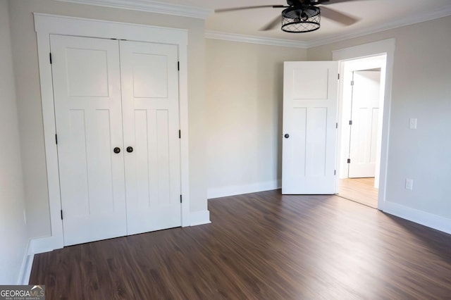 unfurnished bedroom featuring dark wood-style floors, a closet, ornamental molding, and baseboards