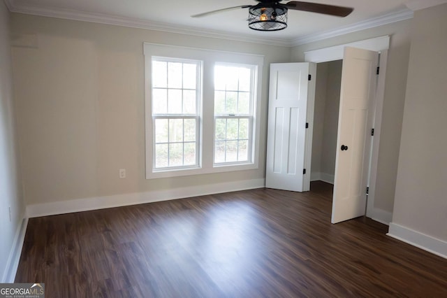 unfurnished bedroom with a ceiling fan, dark wood-style flooring, crown molding, and baseboards