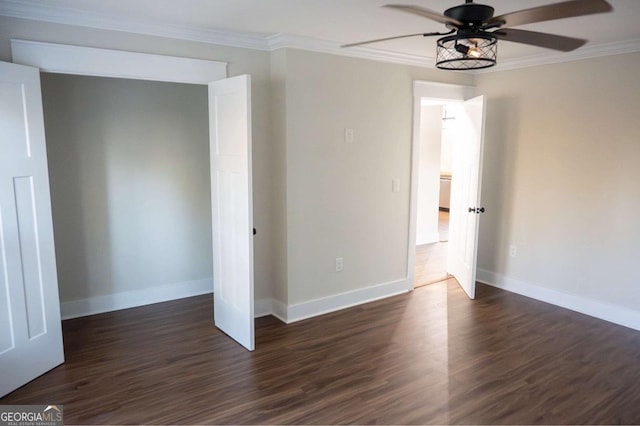 unfurnished bedroom featuring dark wood-style flooring, crown molding, and baseboards